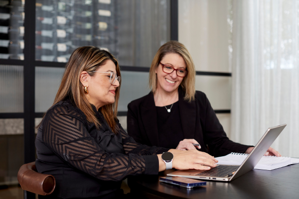 Ameena Basile and Julie Parker working together at a laptop